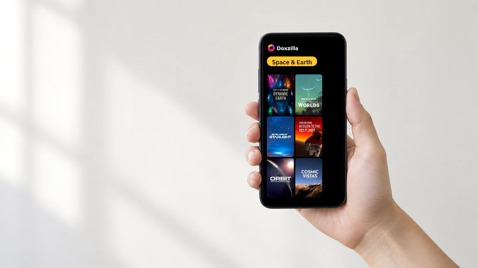 A hand holding a phone showing the Doxzilla app home screen